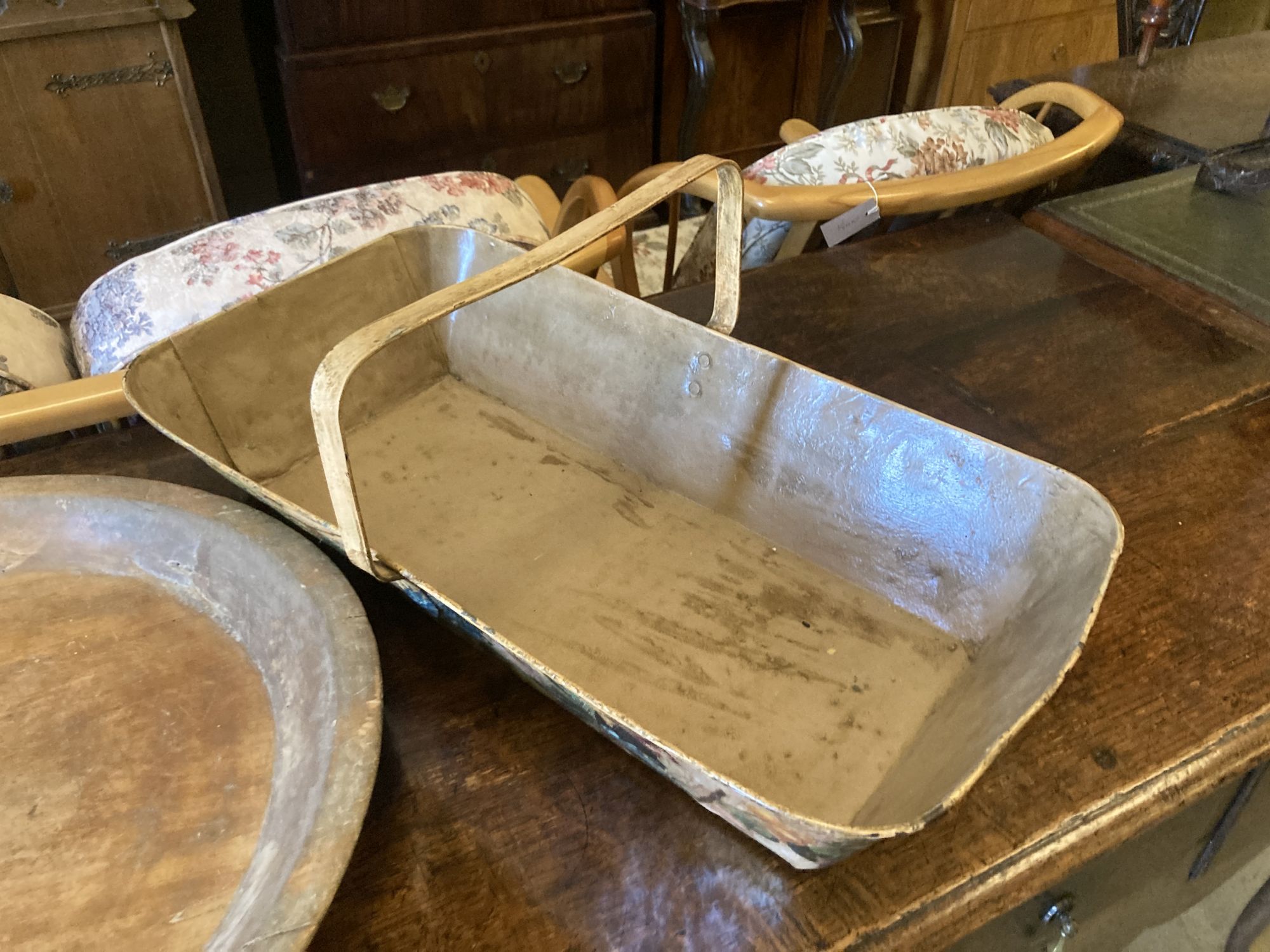 A circular treen shallow bowl and a painted toleware trug, width 69cm, depth 36cm, height 32cm